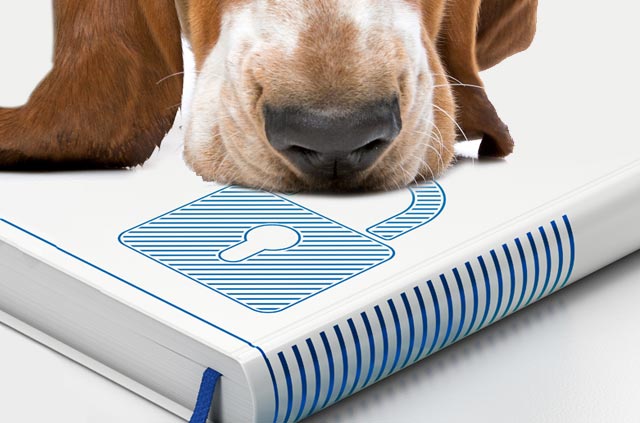 Dog sniffing text book with an image of a padlock.