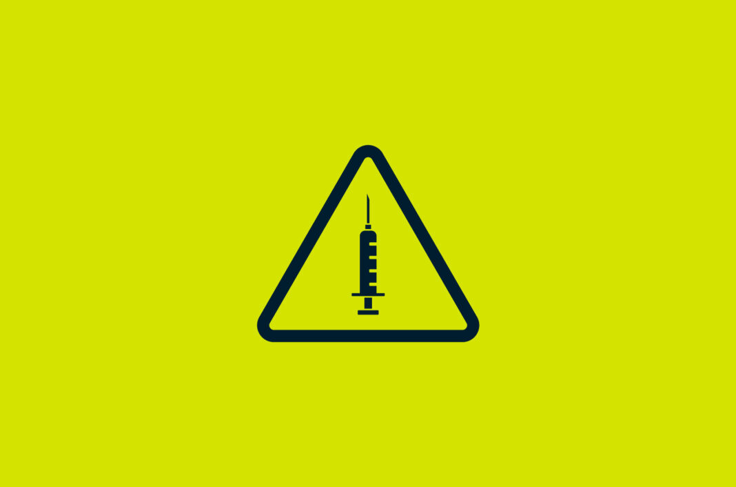 A warning sign with a syringe in the middle.